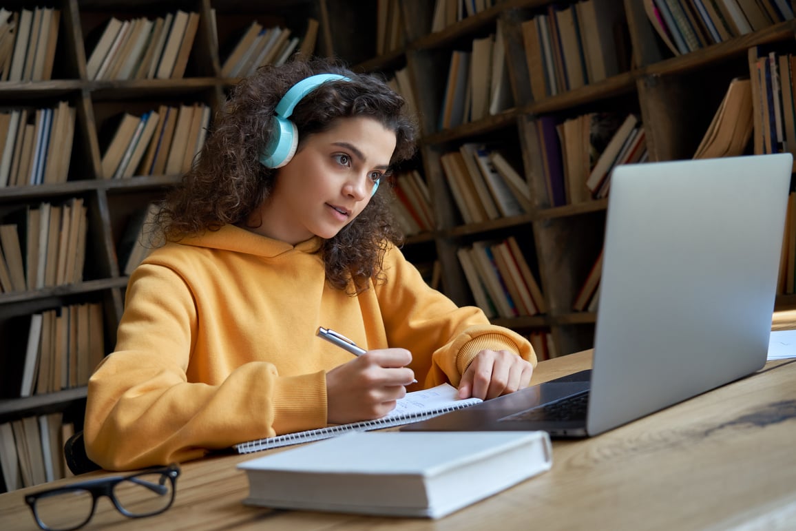 Teen Girl Studying with Laptop at the Library